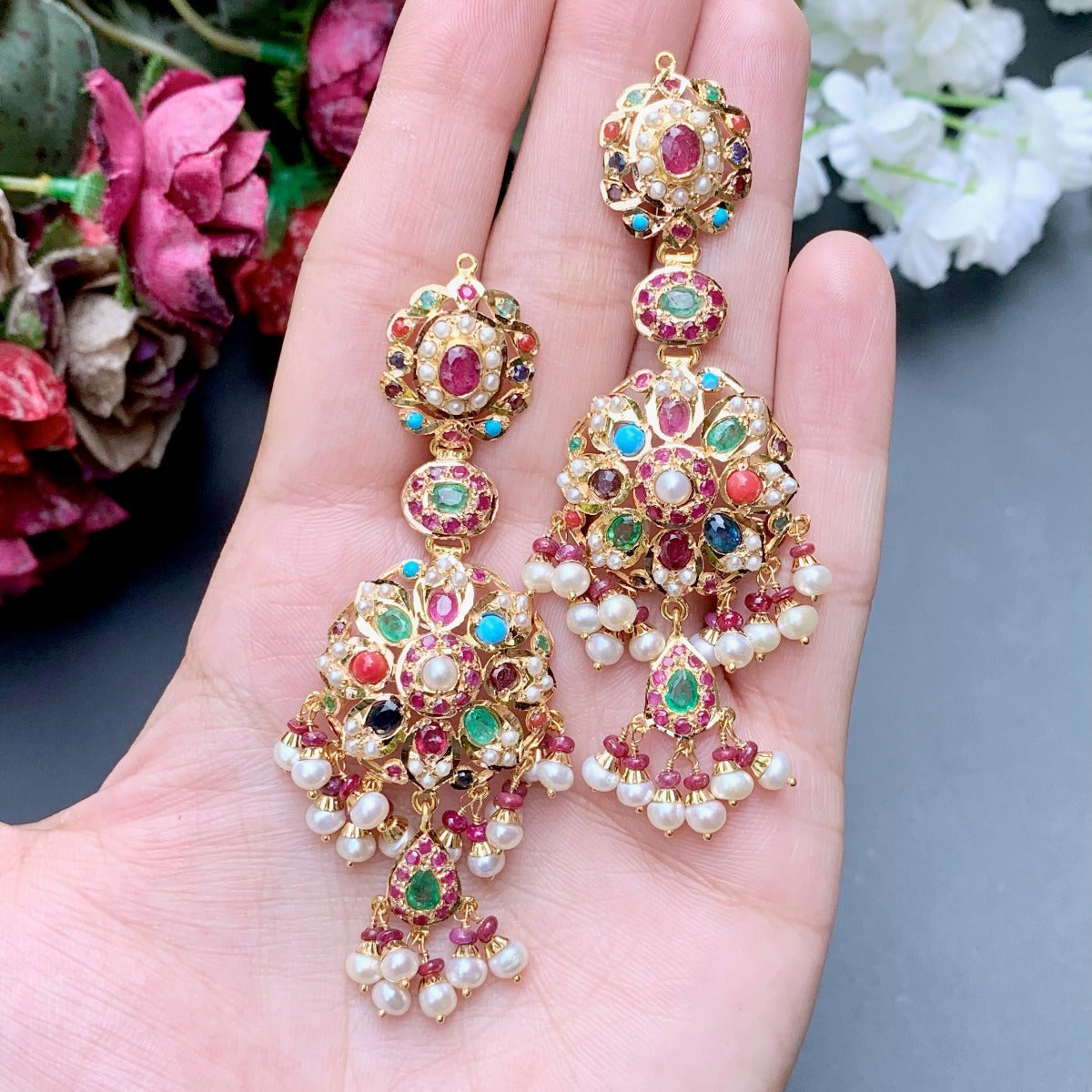 long gold danglers with navratna stones to be worn on elaborate indian functions alongside ethnic dresses like lehenga or suits.