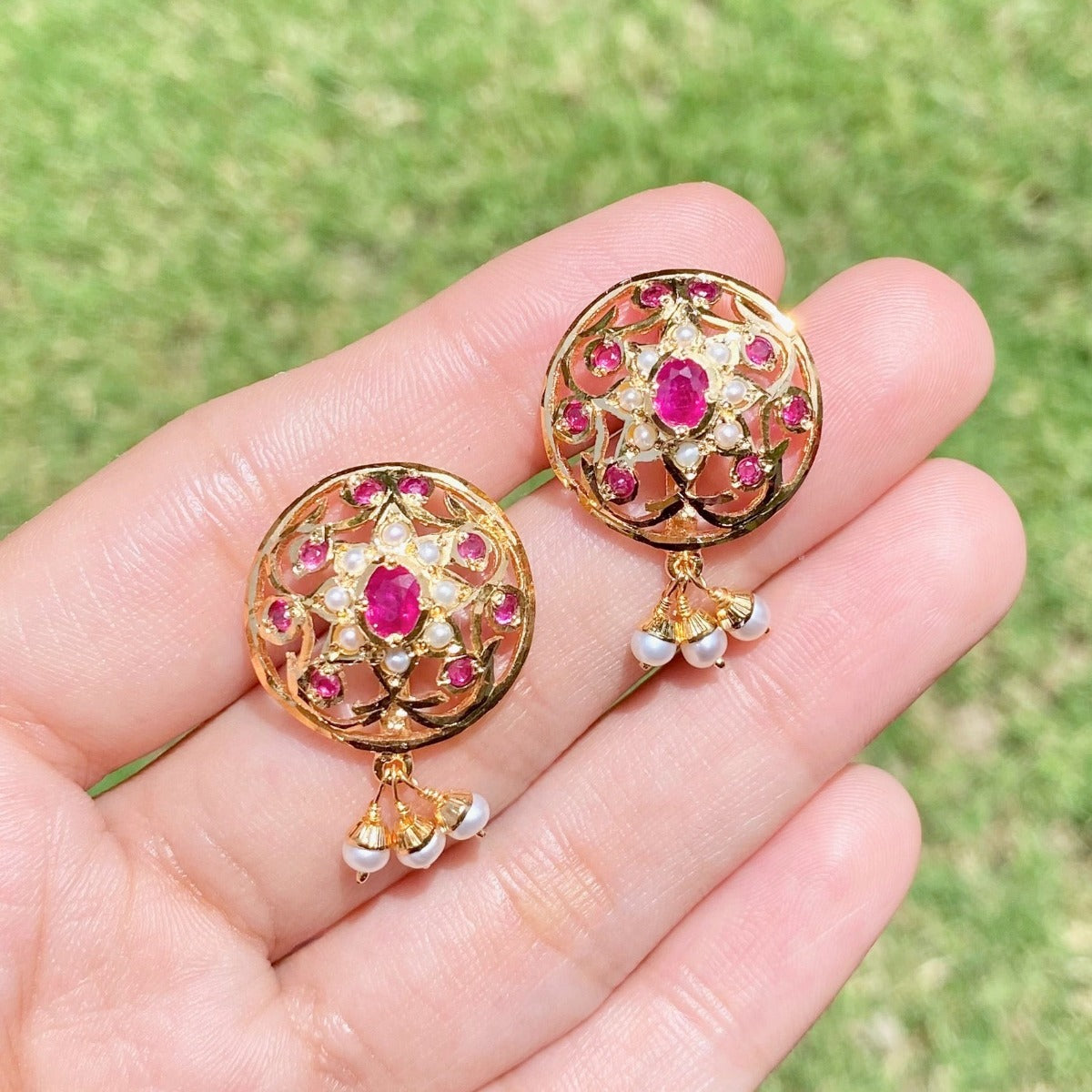 women's stud earrings set with ruby like red stones and pearls on gold plated sterling silver