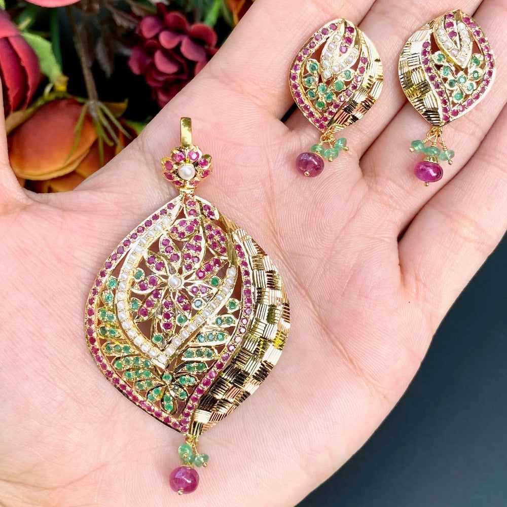 gold pendant set with ruby emerald