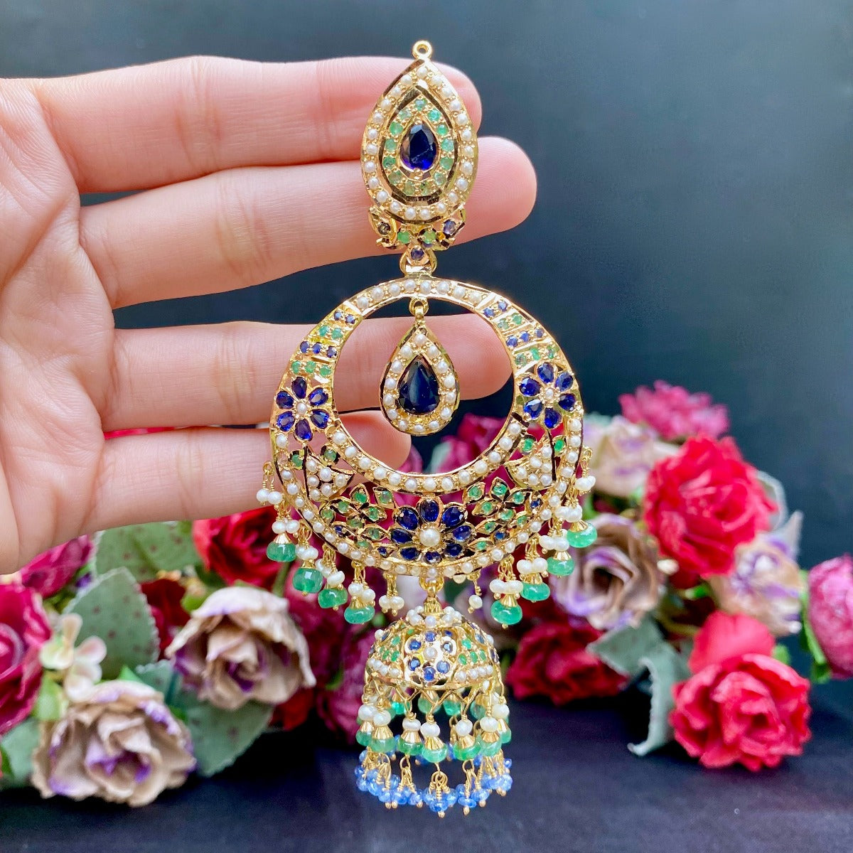 oversized chandbali earrings on gold with a jhumka dangling at the bottom