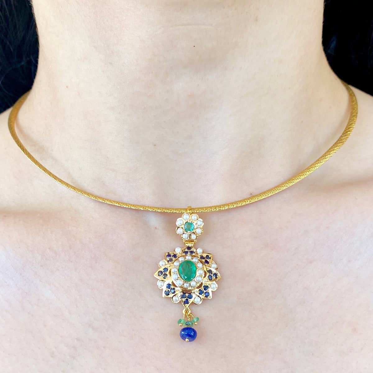 small gold jadau pendant studded with emeralds blue sapphires and pearls